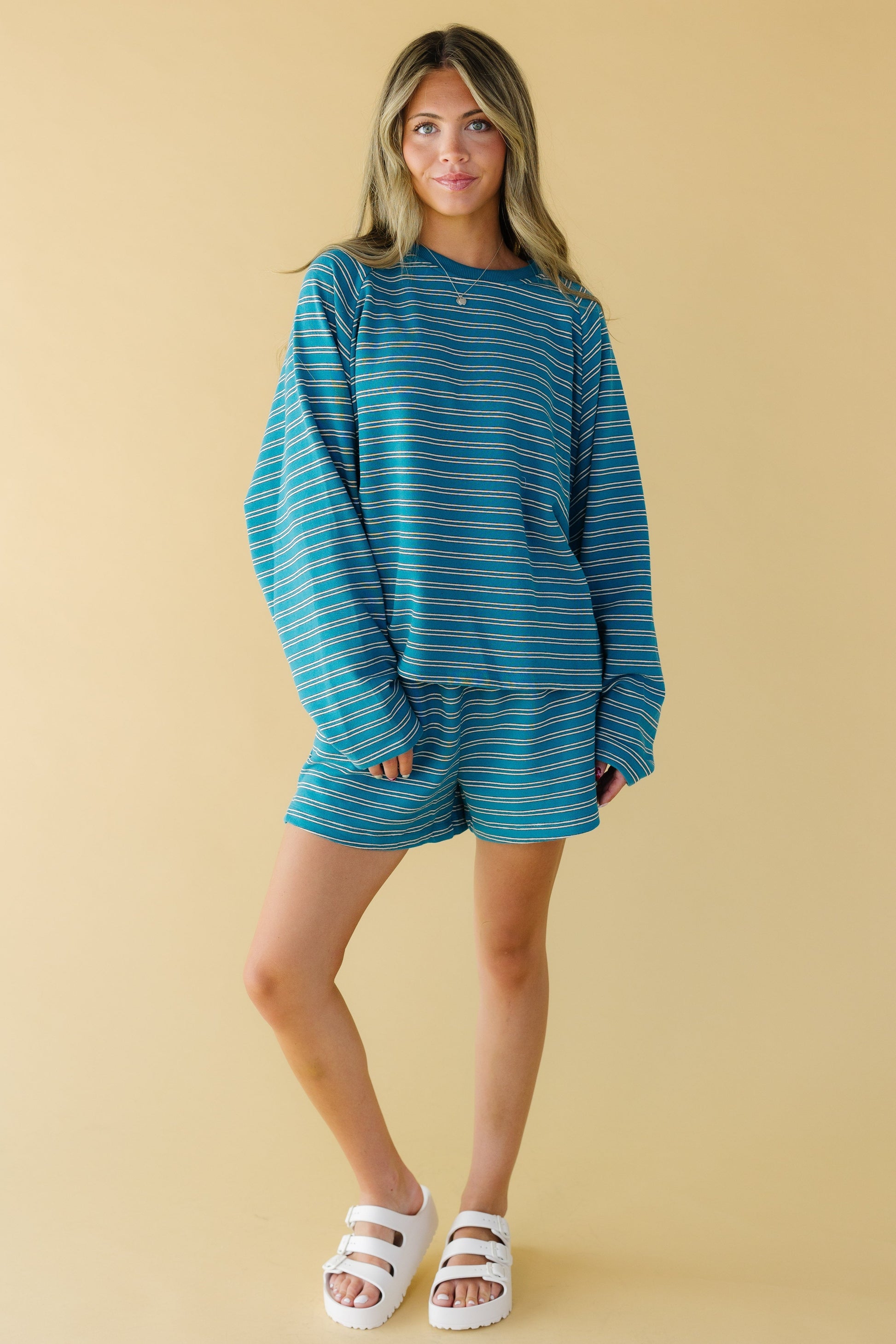Young woman wearing a loose fitting short set with a loose fitting long sleeve top and wide leg shorts.