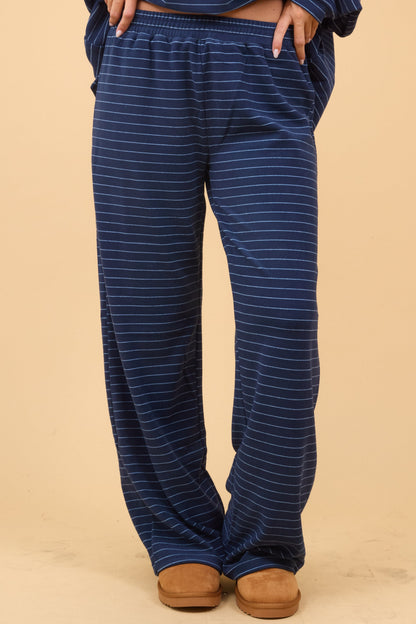 Young woman wearing modest loose fitting, navy stripe lounge pants with an elastic waist.