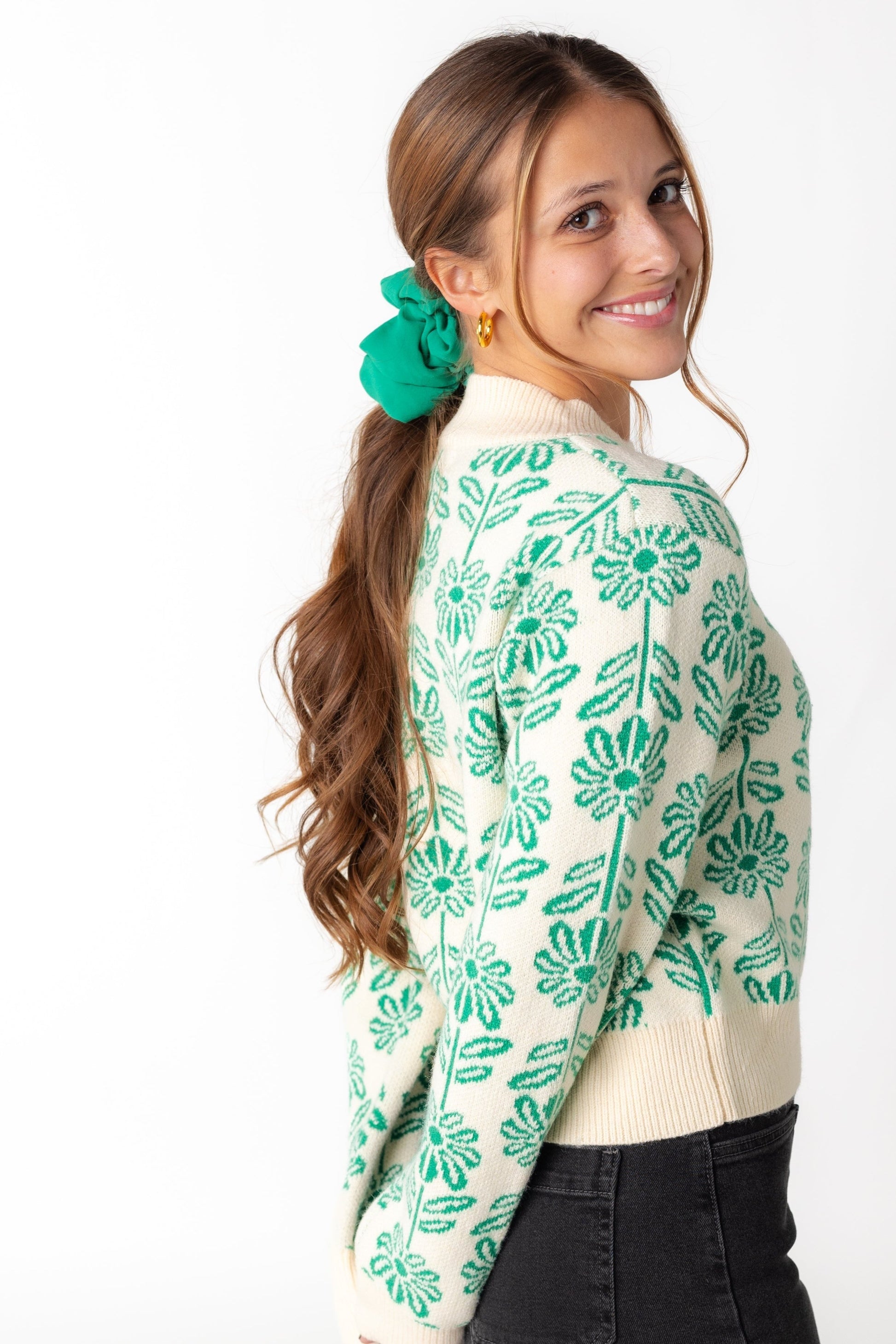 Side view of green floral sweater with long sleeves
