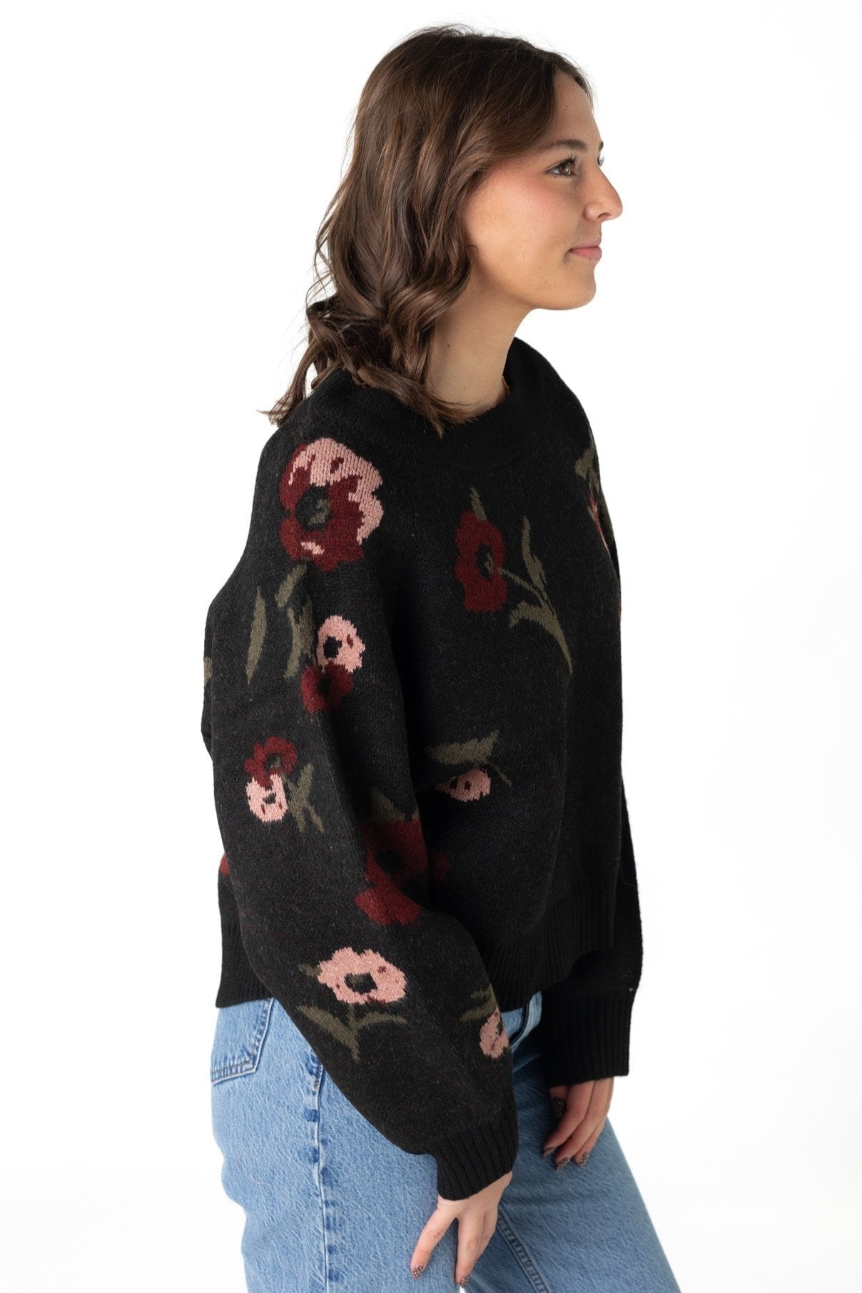 Side view of black sweater with floral pattern down long sleeves