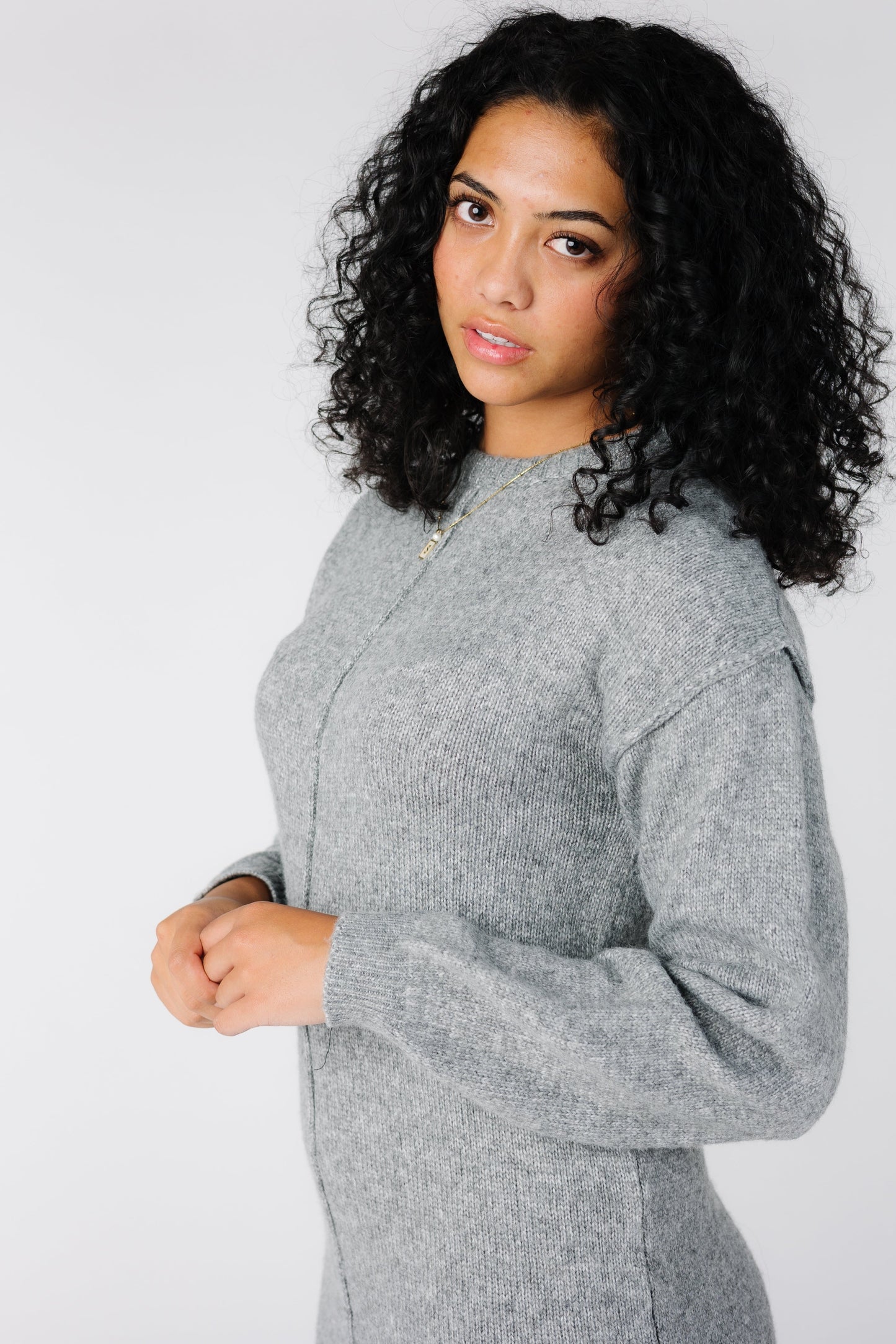 Close view of grey sweater dress with crew neckline and long sleeves