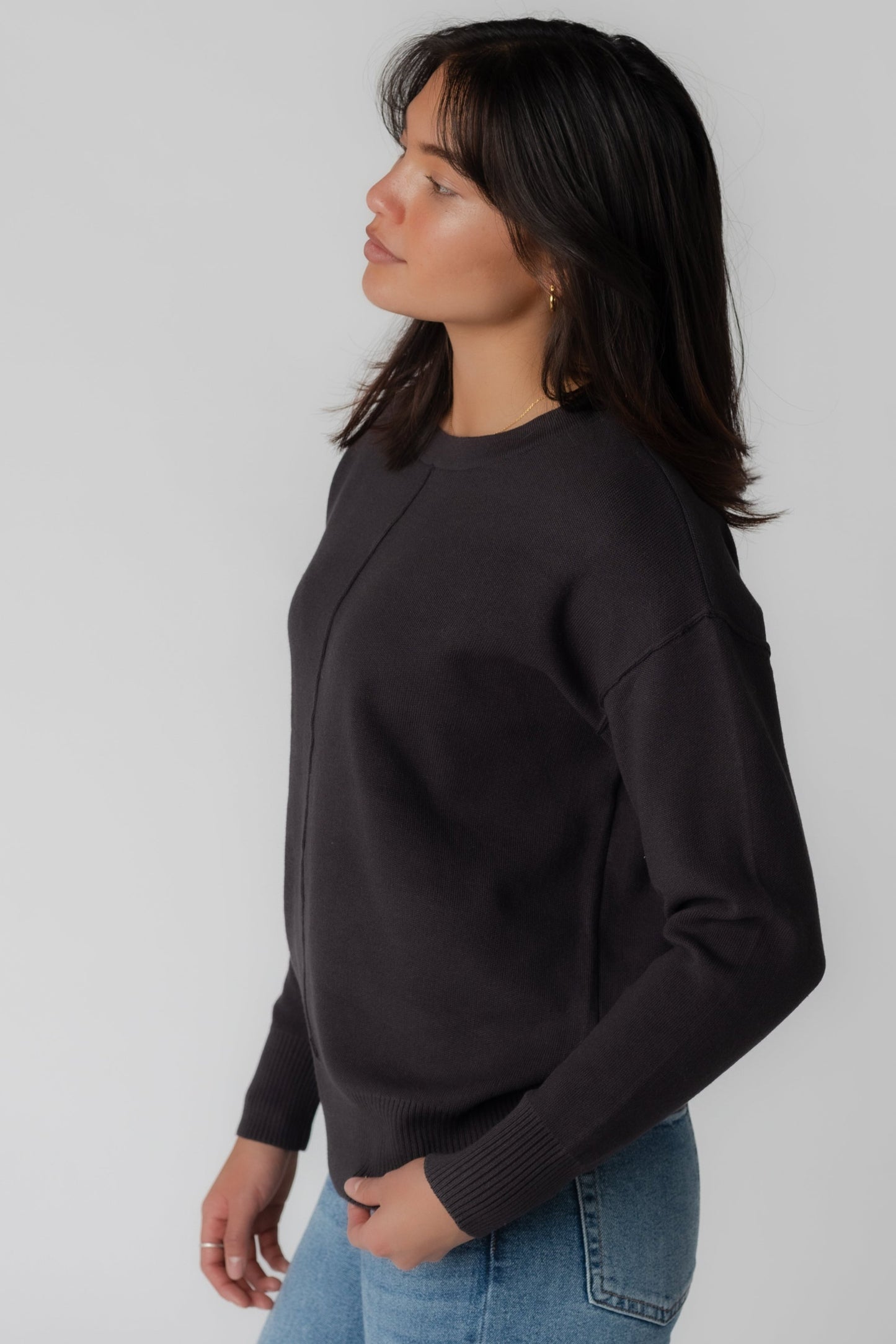 Side view of charcoal long sleeve sweater with crew neckline