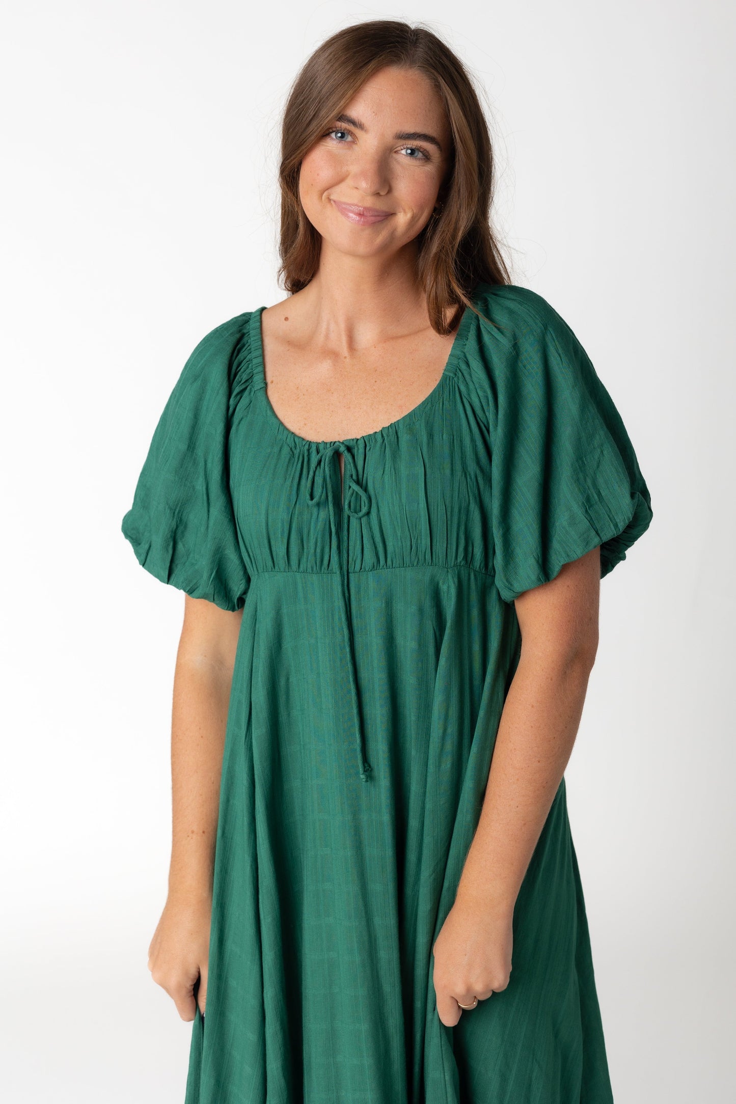 Close view of emerald green midi dress with textured stripe details with full skirt