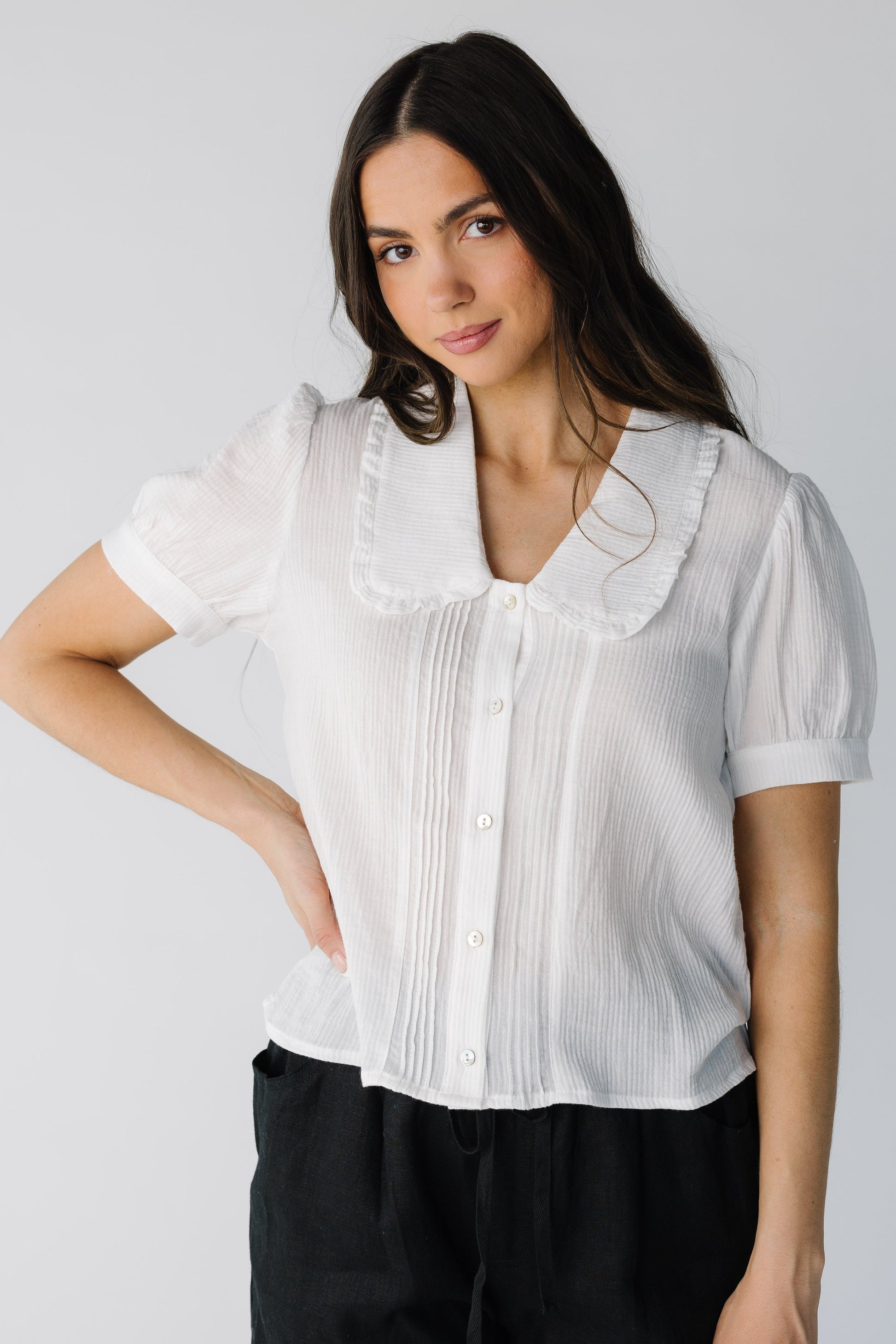 Lighteight ivory button down top with V-neckline and wide ruffle trimmed lapels