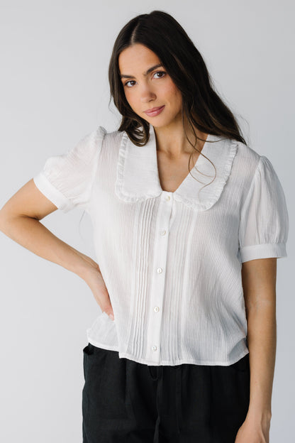 Lighteight ivory button down top with V-neckline and wide ruffle trimmed lapels