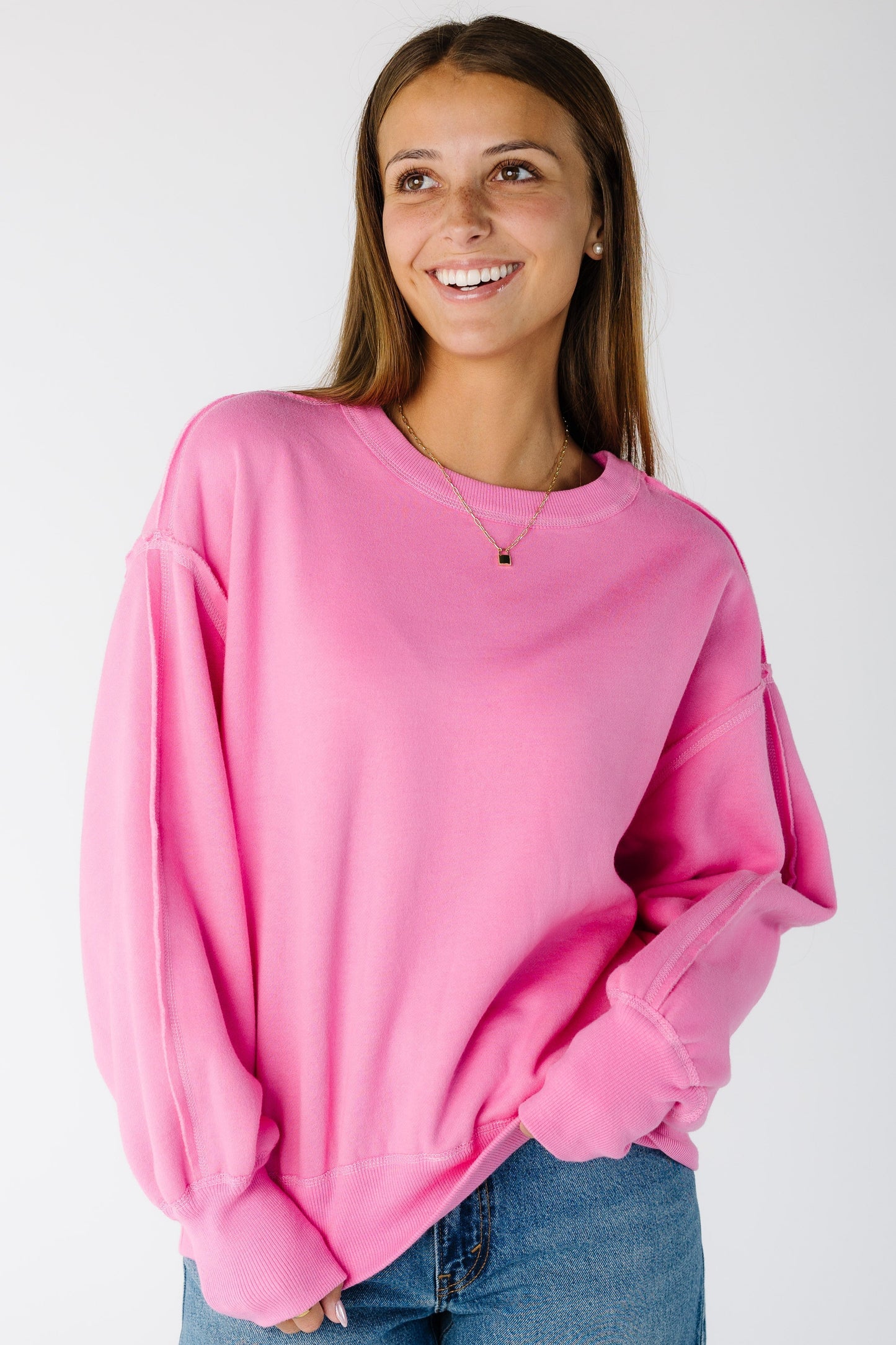 Woman wearing a modest pink sweatshirt with crew neckline and long sleeves
