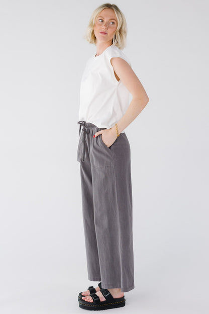 Young woman wearing a wide leg, loose pants in charcoal.