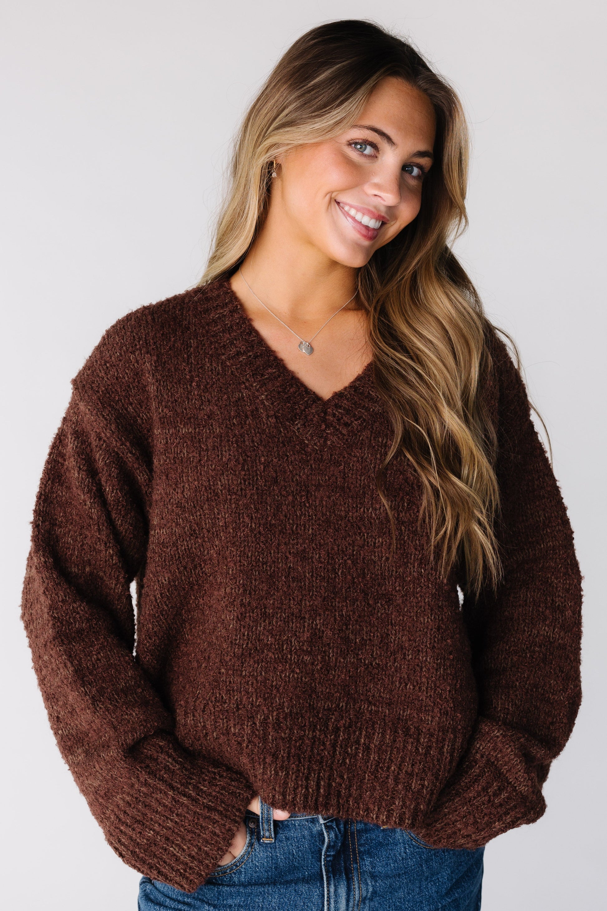 Woman wearing a bulky brown long sleeve sweater