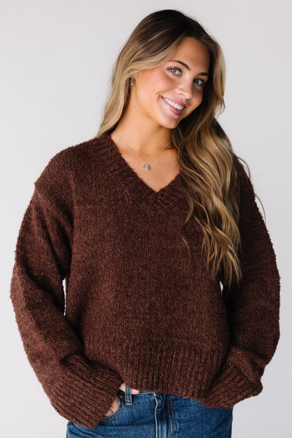 Woman wearing a bulky brown long sleeve sweater