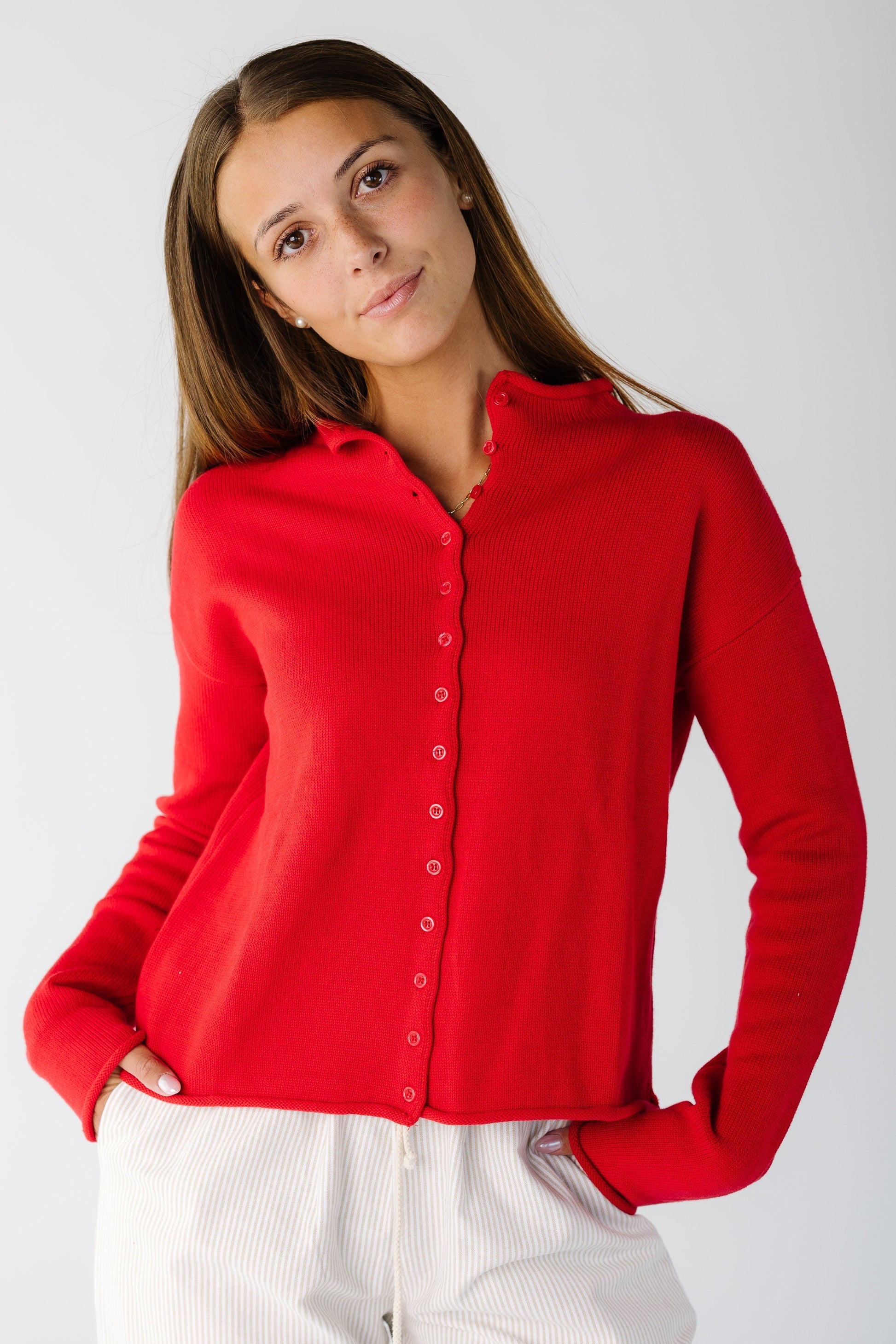 Woman wearing a red button cardigan with long sleeves and round collar