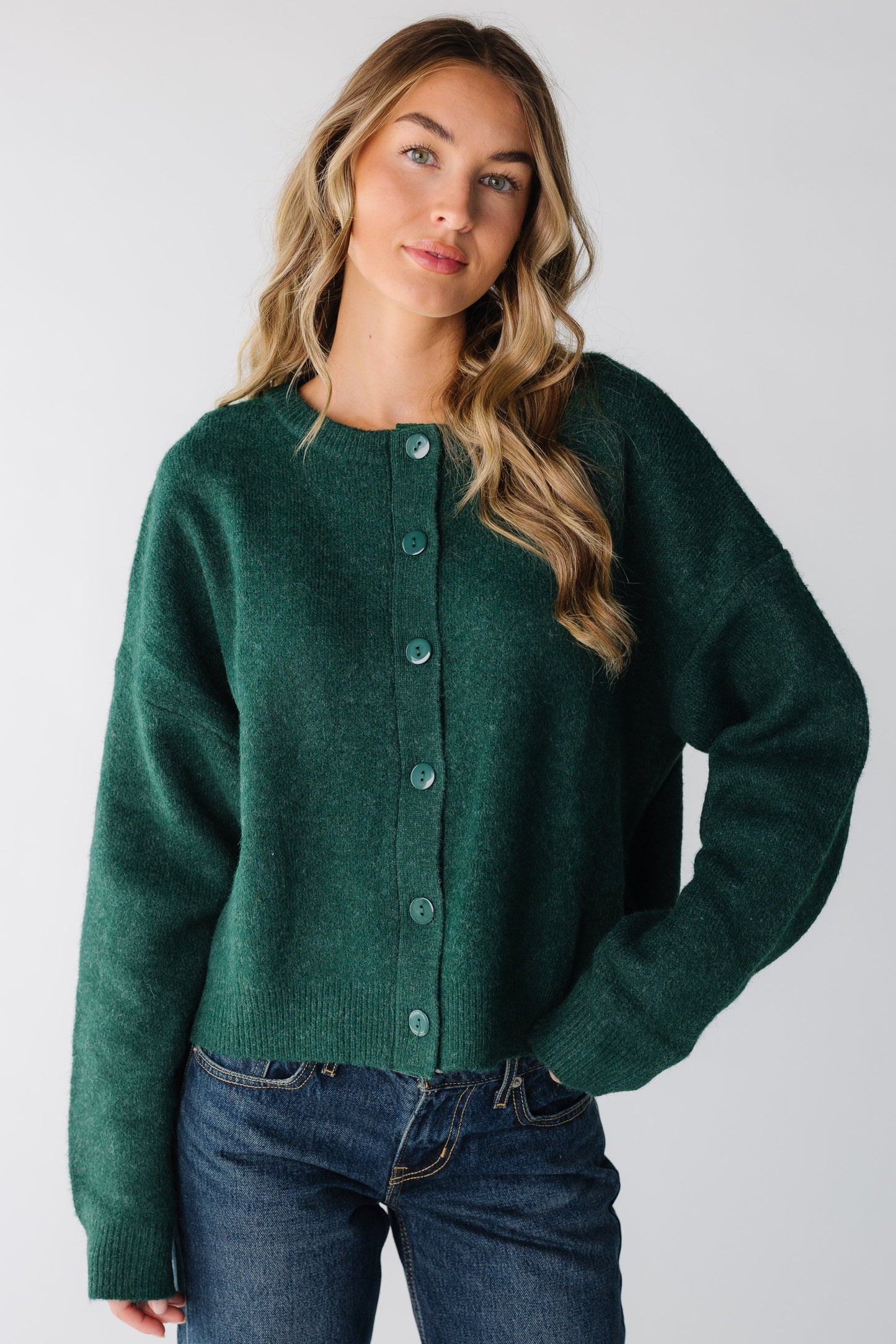 Woman wearing a forest green modest button down cardigan with long sleeves