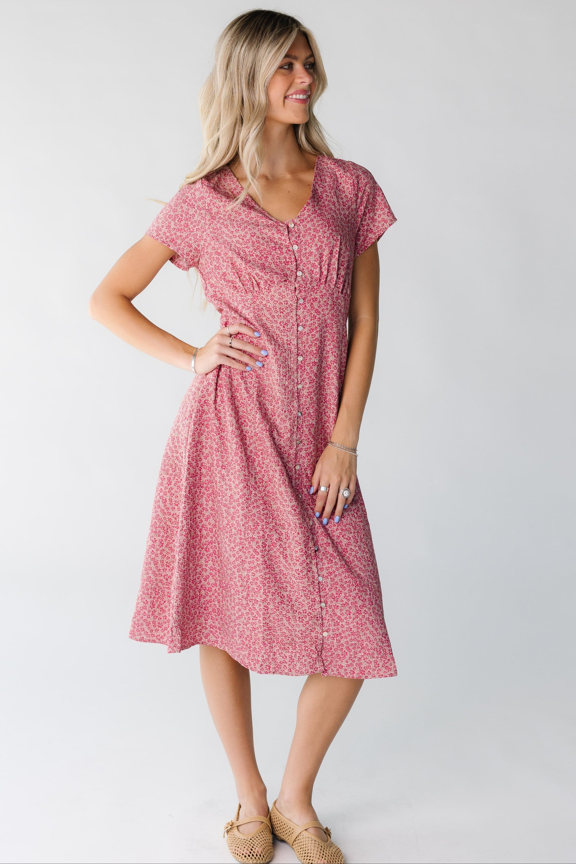 Woman wearing a pink floral button down dress with short sleeves