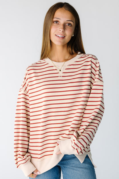 Woman wearing a modest beige and brick stripe long sleeve tee with a crew neckline with long sleeves
