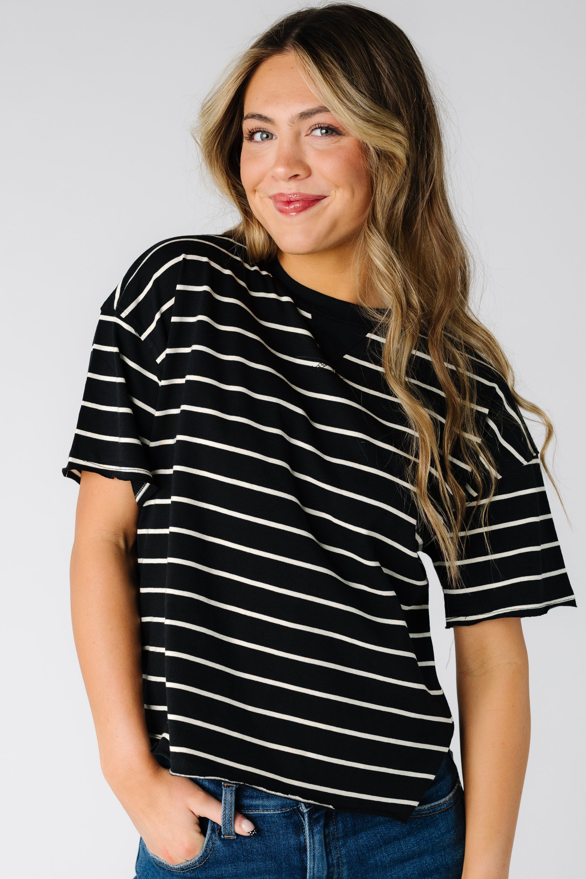 Woman wearing a modest short sleeve tee in black with white stripes with a crew neckline.
