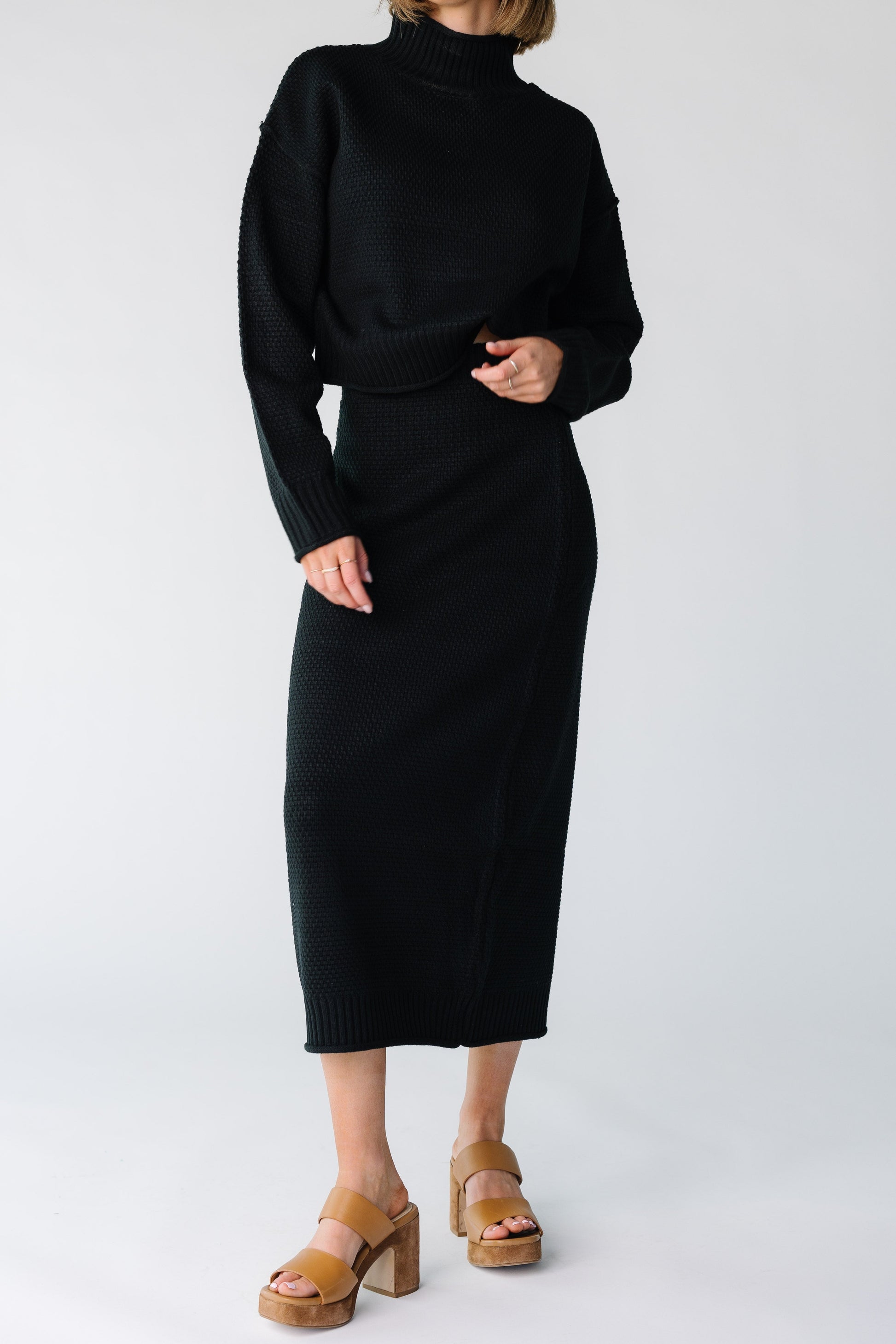 Close view of a woman wearing a black textured sweater midi skirt