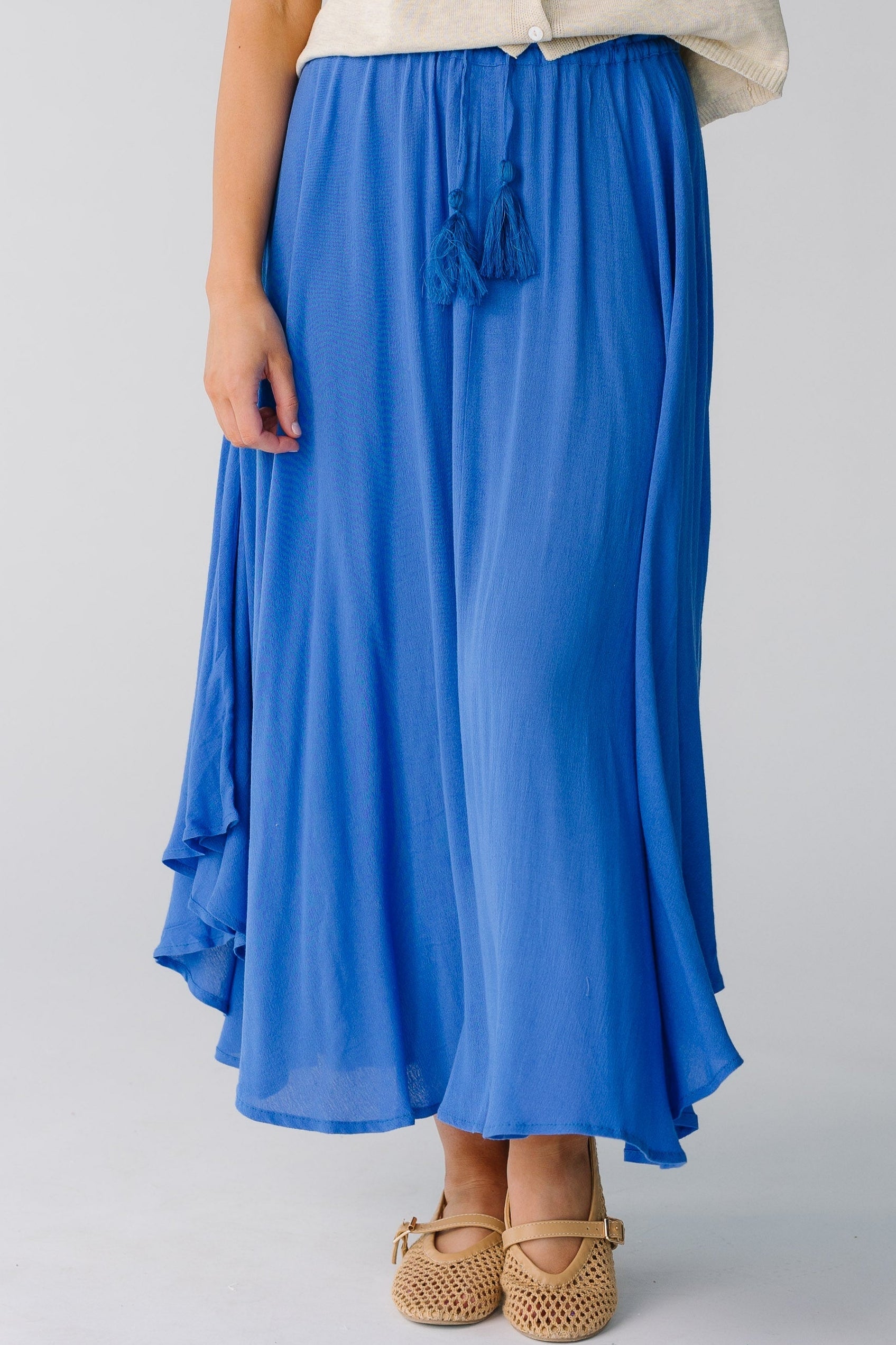 Blue curved hem skirt with tasseled belt
