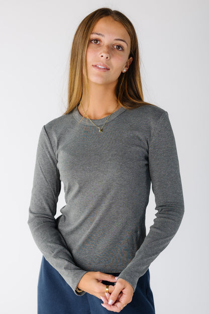 Woman wearing a modest grey top with a crew neckline and long sleeves