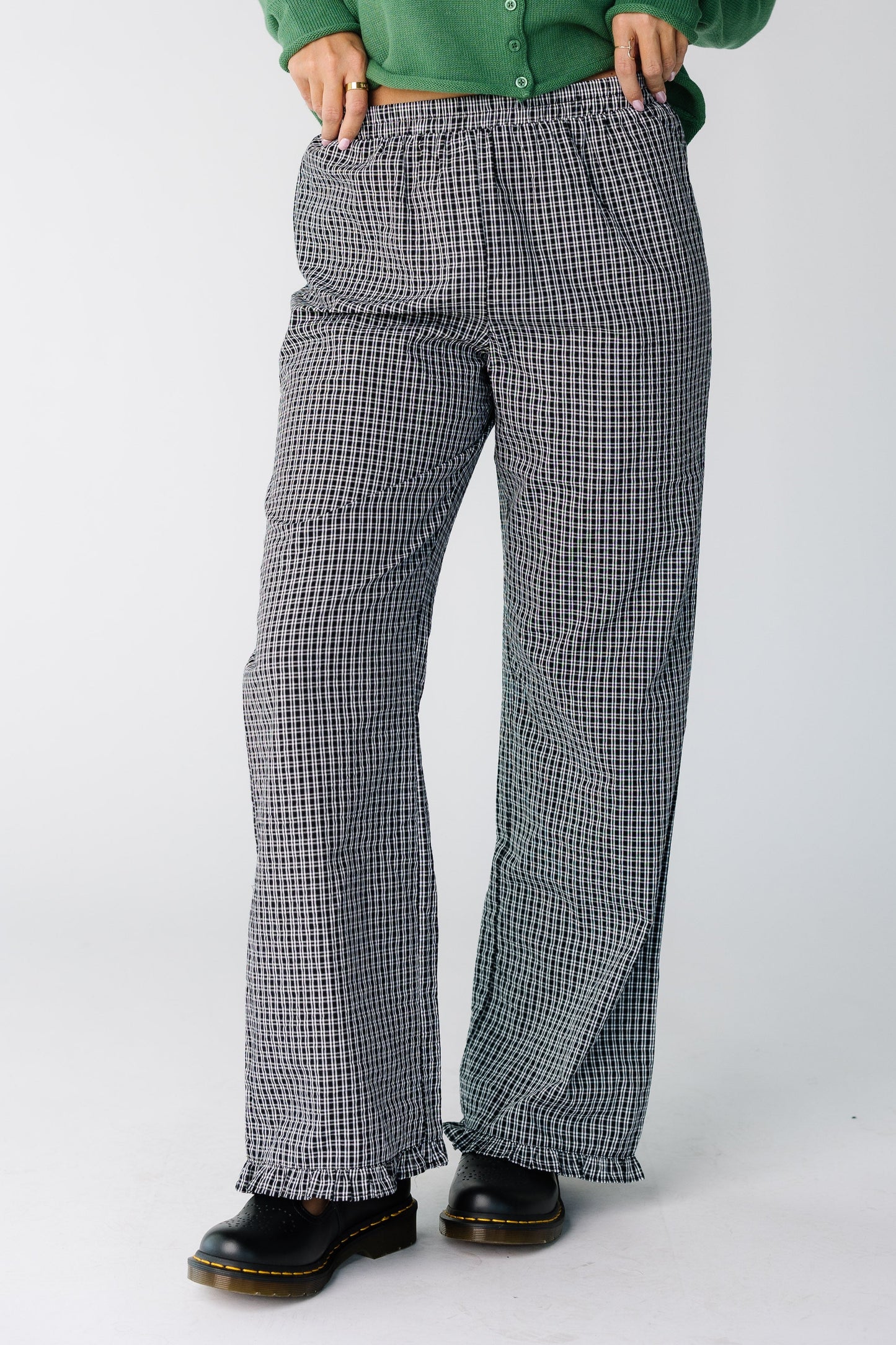 Woman wearing a pair of black and white plaid pants with a ruffle hem