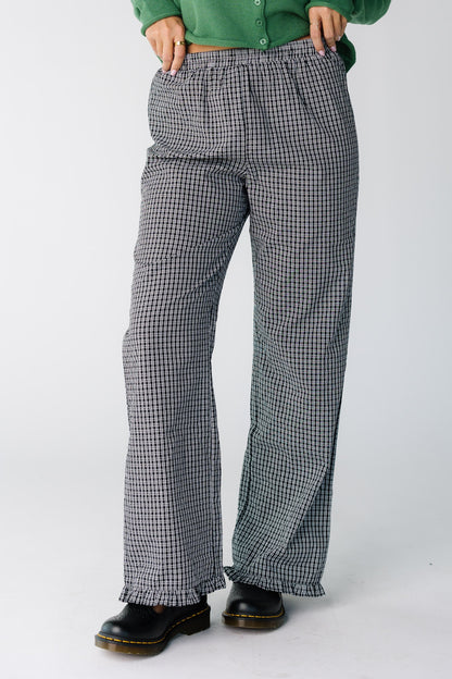 Woman wearing a pair of black and white plaid pants with a ruffle hem