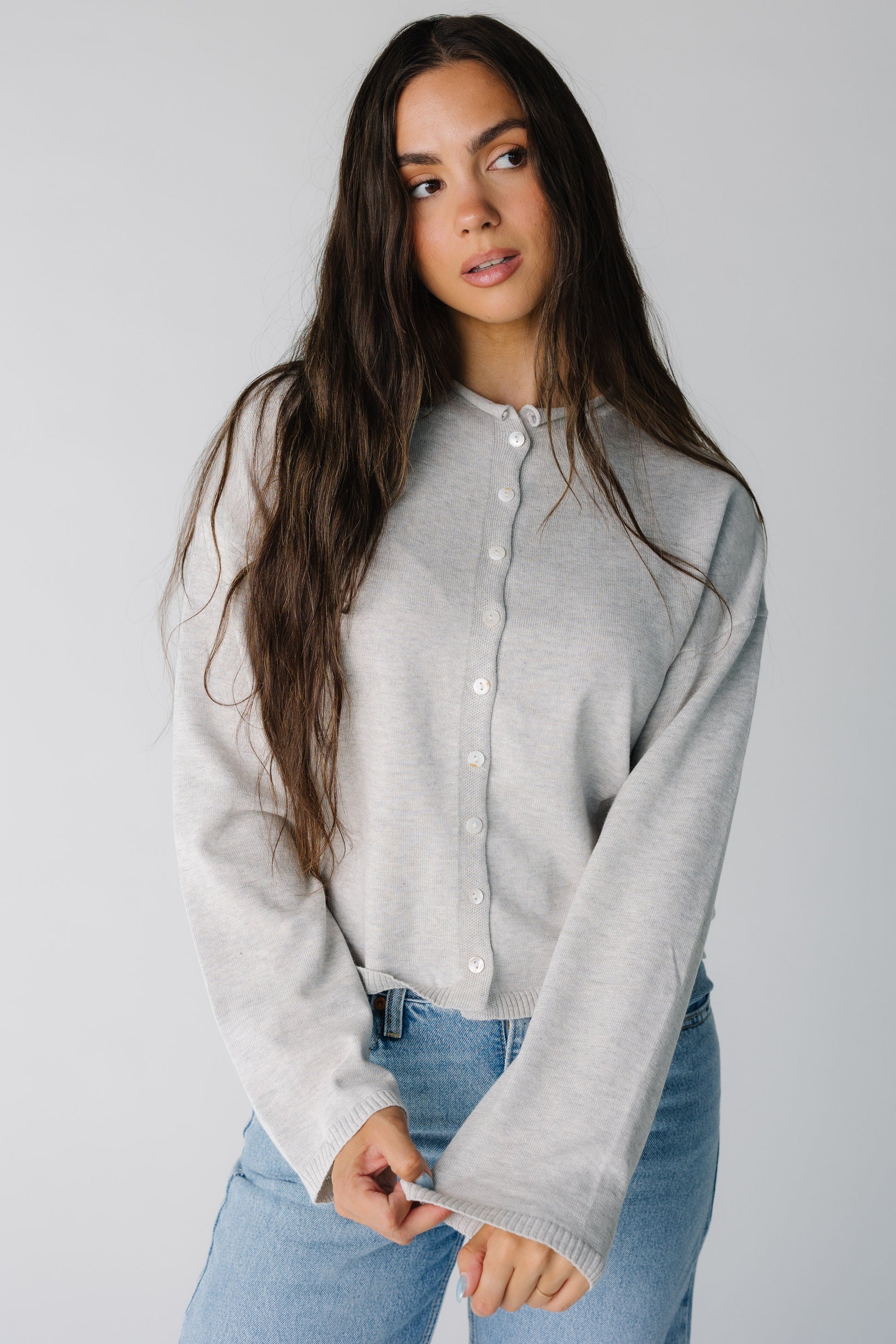Woman wearing heather grey button down cardigan with a round neckline and long sleeves
