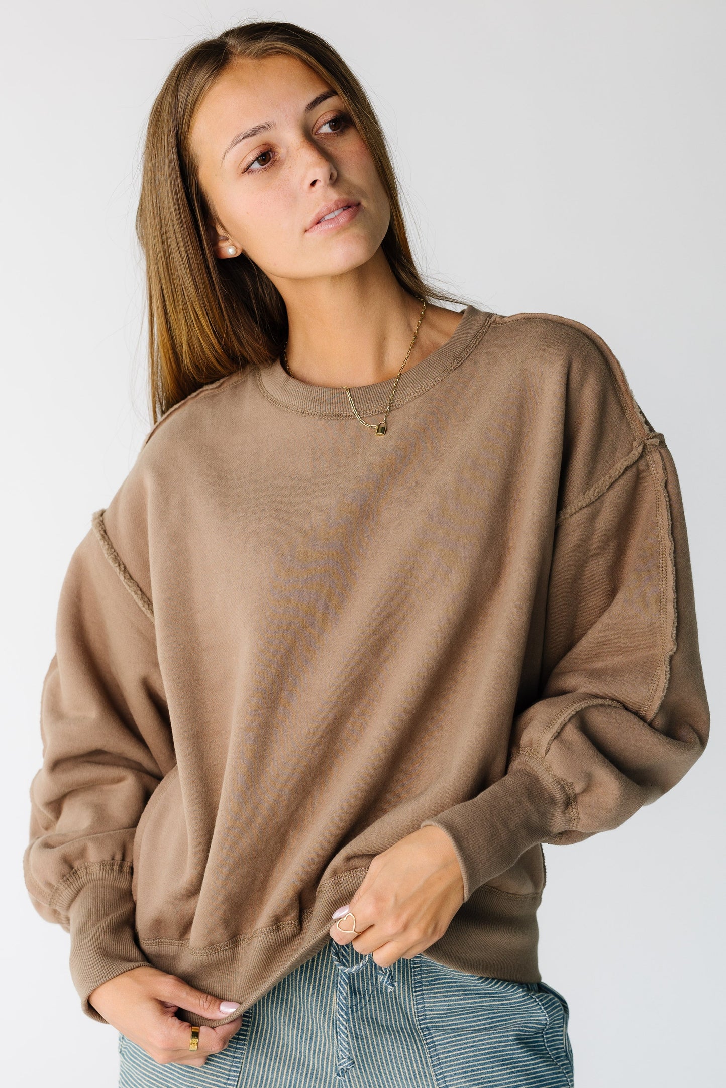 Woman wearing a modest soft brown sweatshirt-sweater with a crew neckline and long sleeves