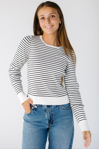 Woman wearing a modest long sleeve white & black sweater with crew neckline 