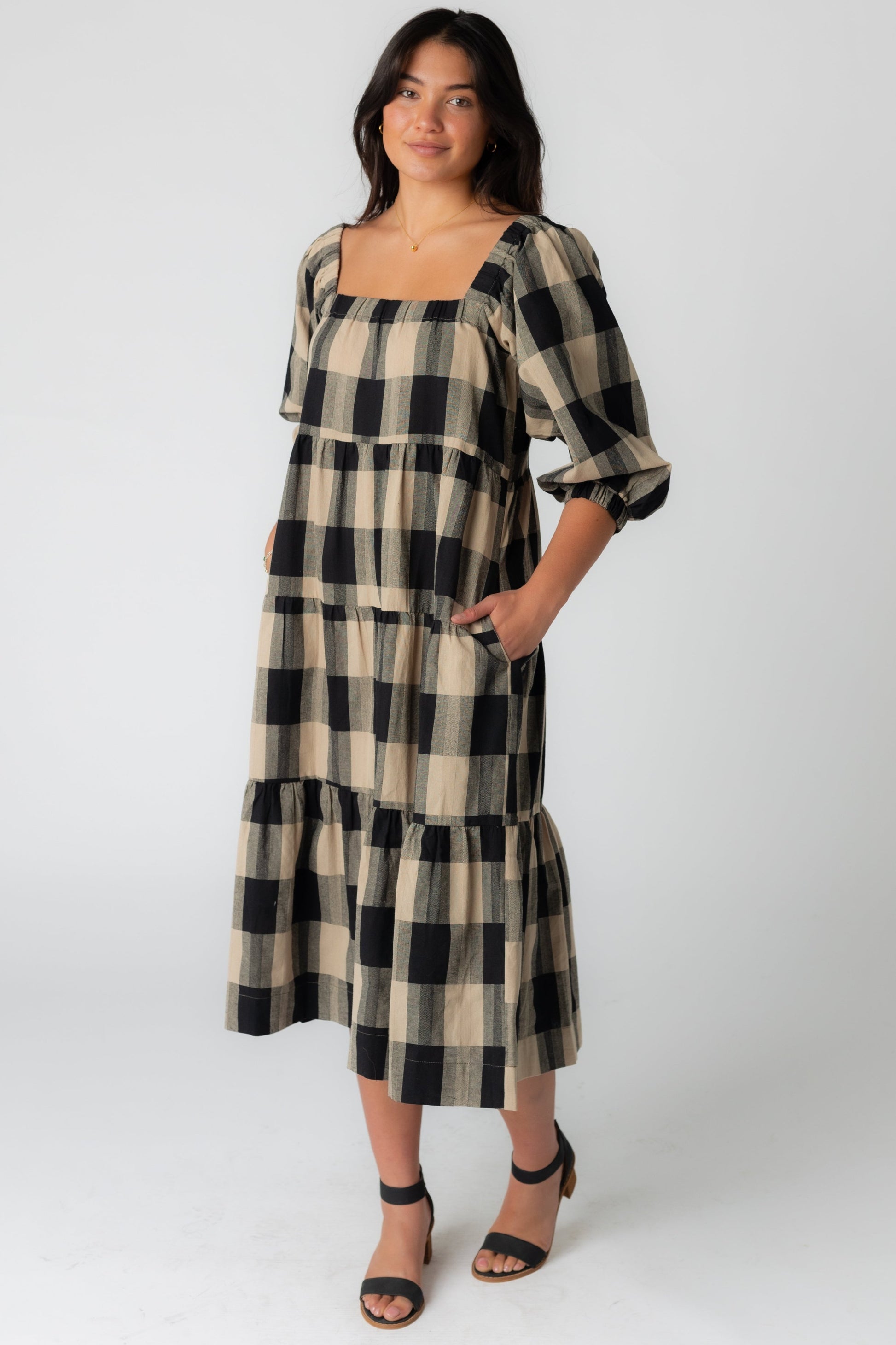 Black and tan plaid midi dress with square neckline half length sleeves and wide bottom ruffle