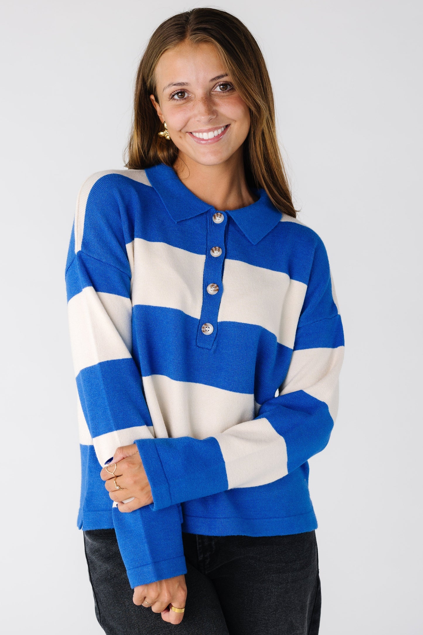 Woman wearing a wide stripe sweater with short button placket in blue and white