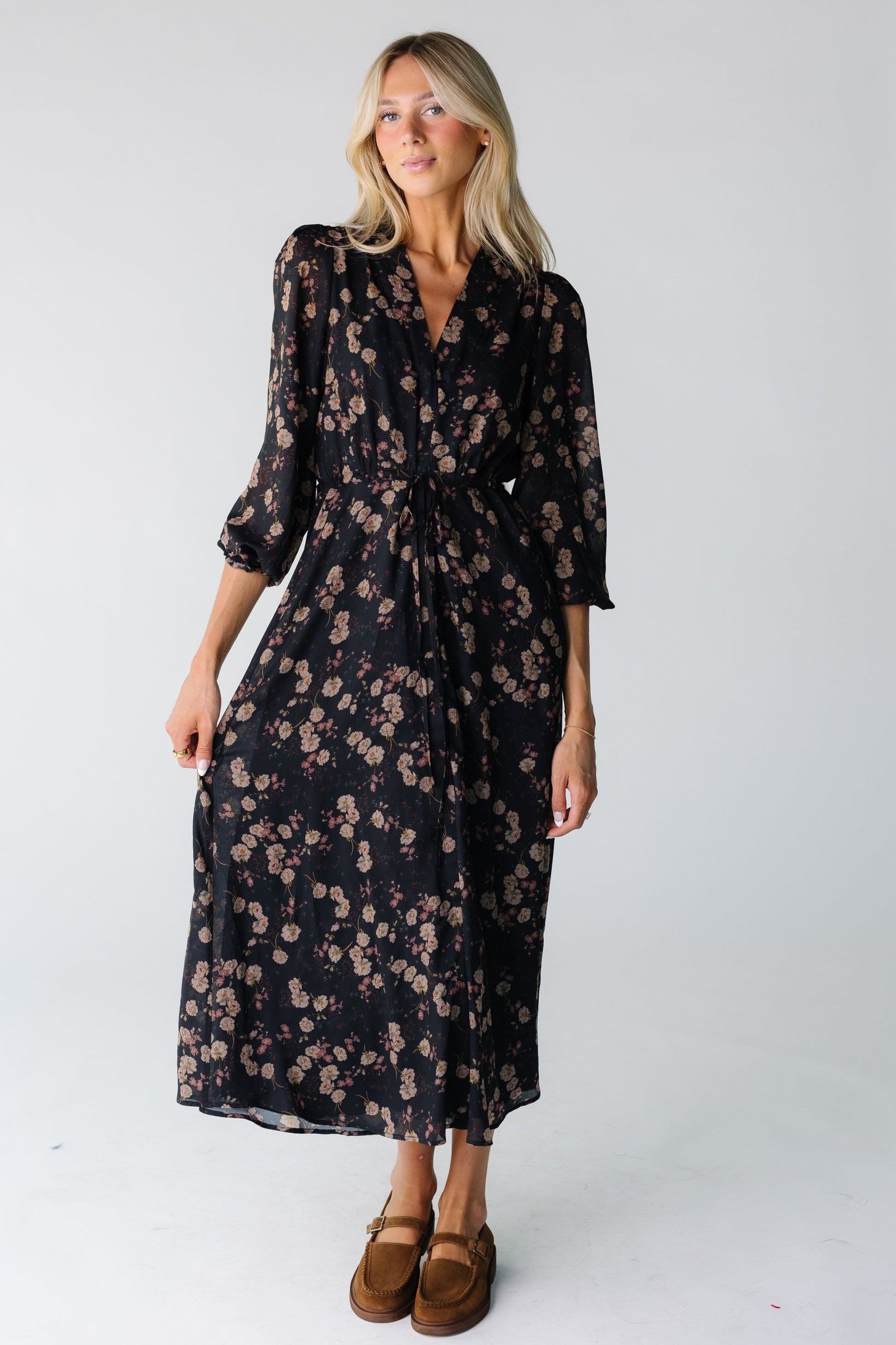 Woman wearing a black floral print chiffon dress with V-neckline