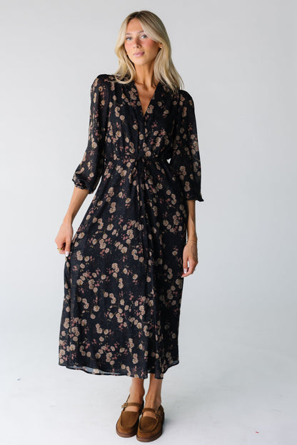 Woman wearing a black floral print chiffon dress with V-neckline