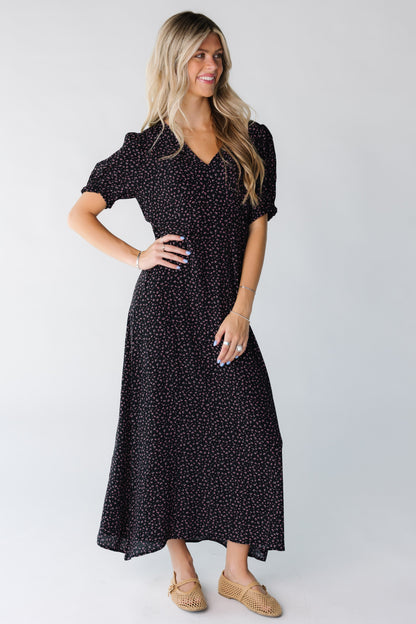 A woman wearing a black print midi dress