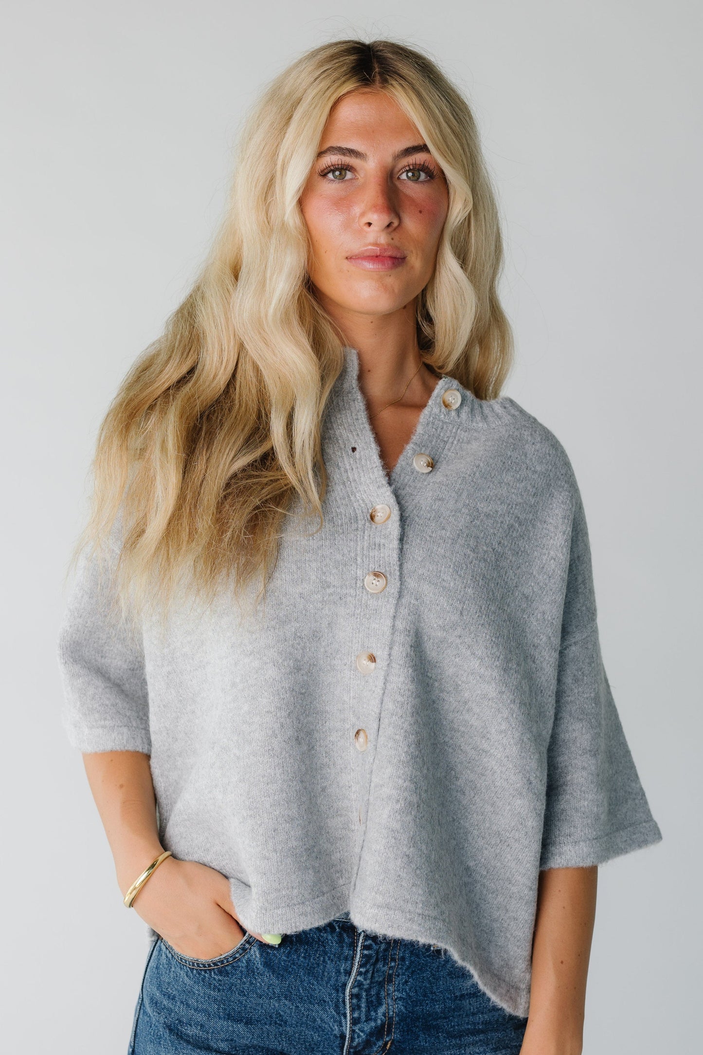 Woman wearing a grey button down cardigan with half length sleeves