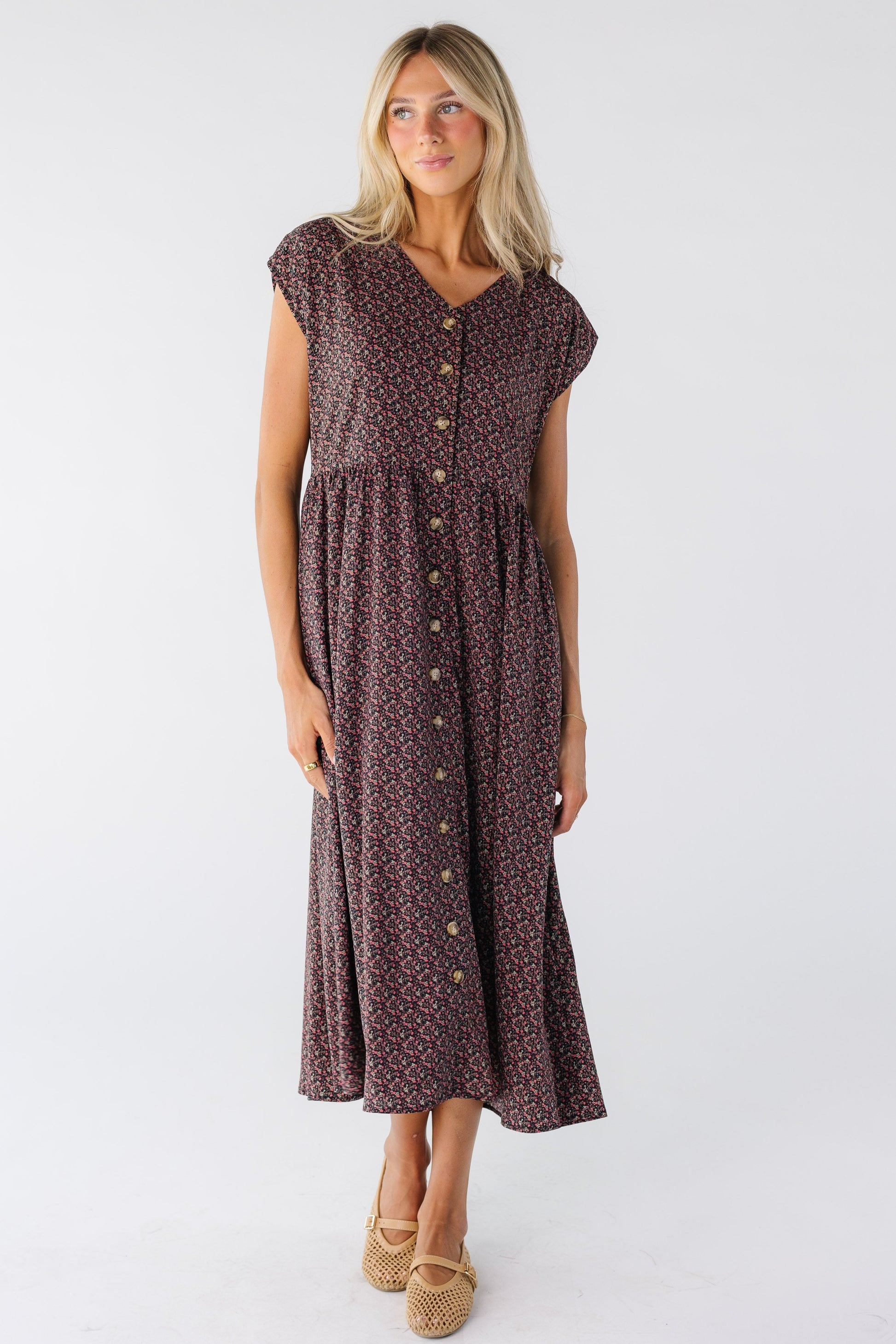 A women wearing a button down dress in black floral print