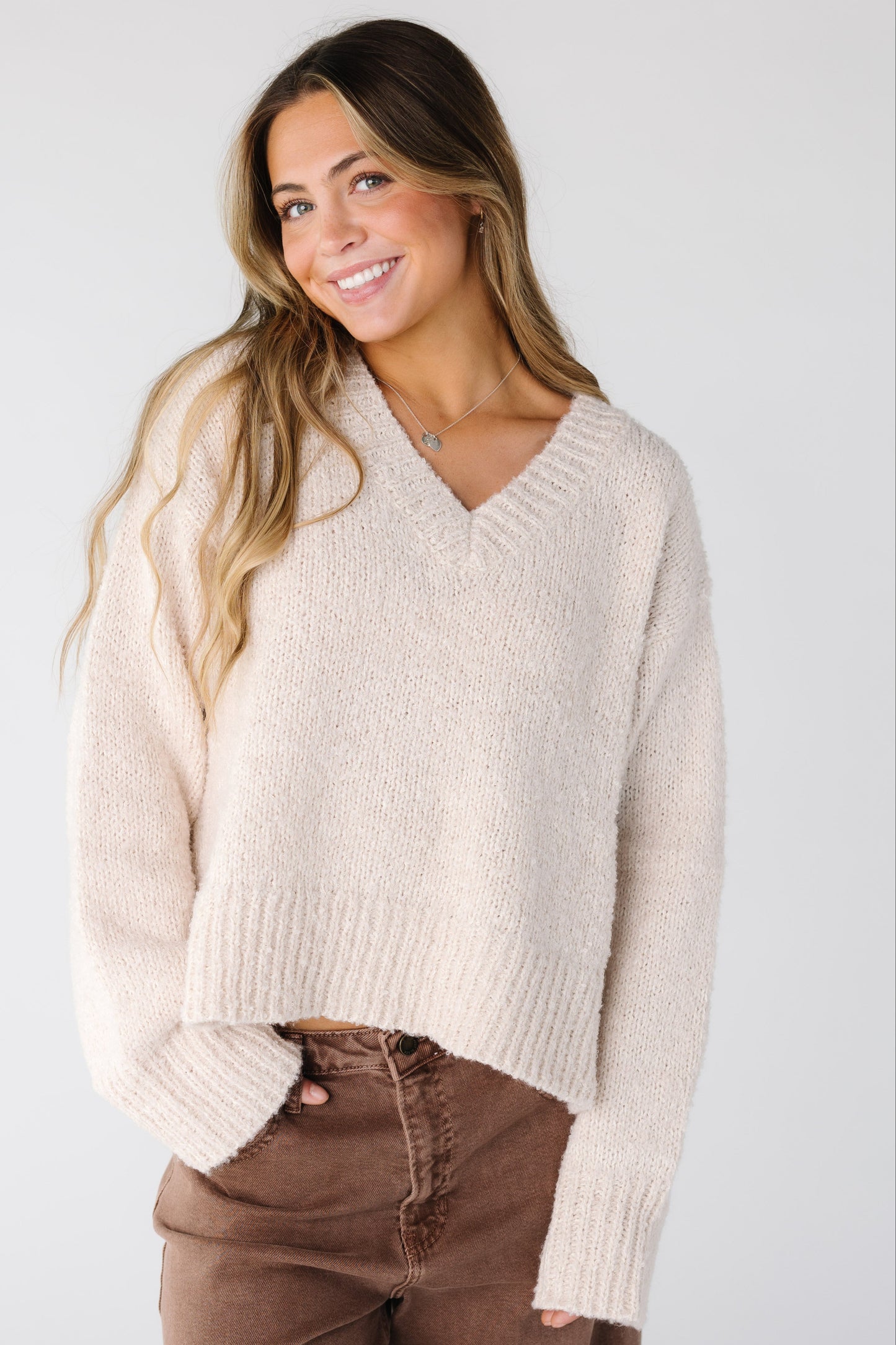 Woman wearing a loose fitting sweater in cream