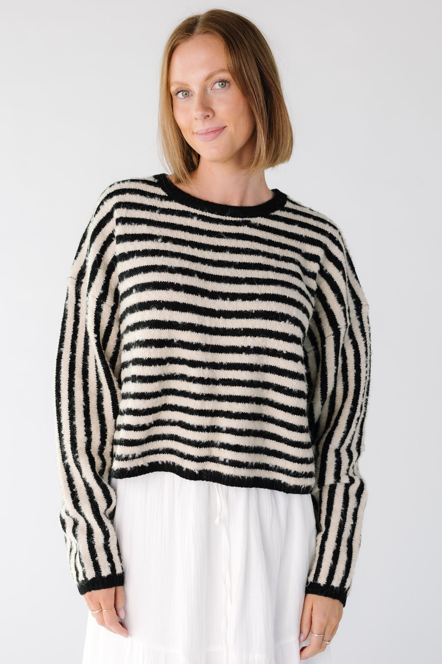 Woman wearing a long sleeve black and white stripe sweater