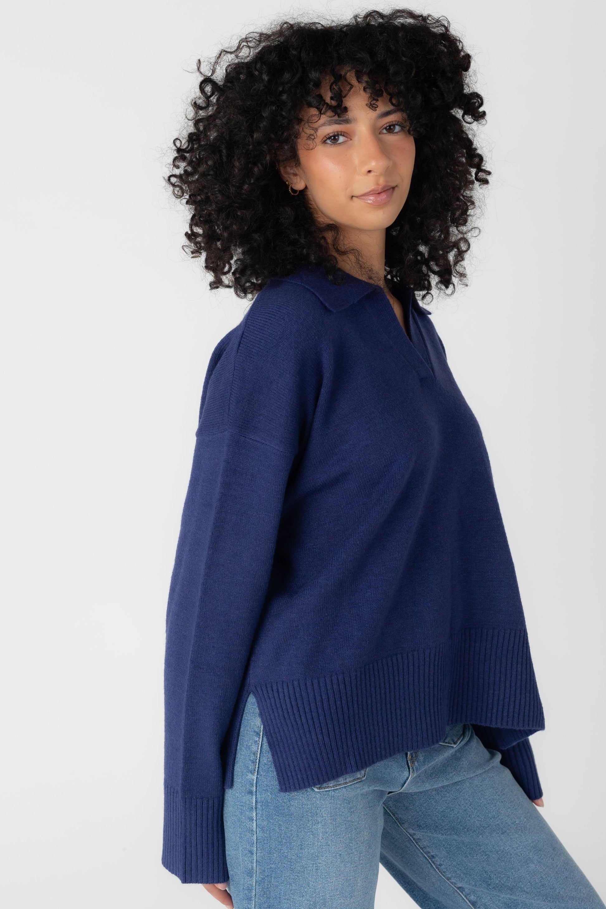 Side view of long sleeve navy sweater with short side slits