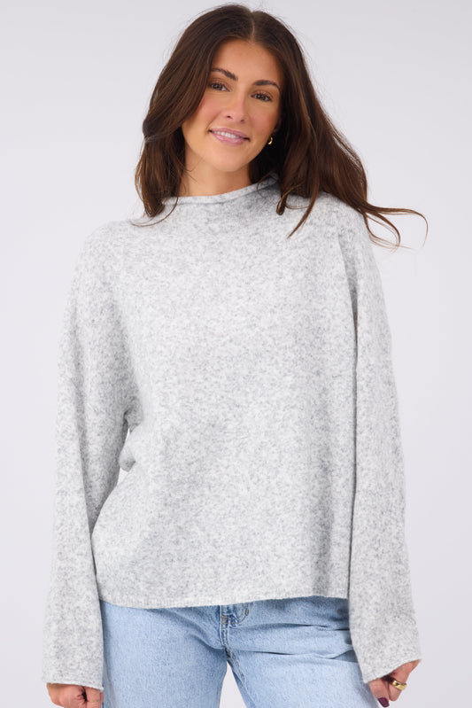 a young woman wearing a modest and soft pullover sweater with a mock neckline and long sleeves in heather grey.
