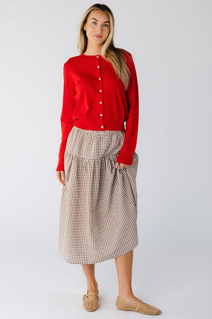 Woman wearing a brown and cream gingham midi skirt with drop waist
