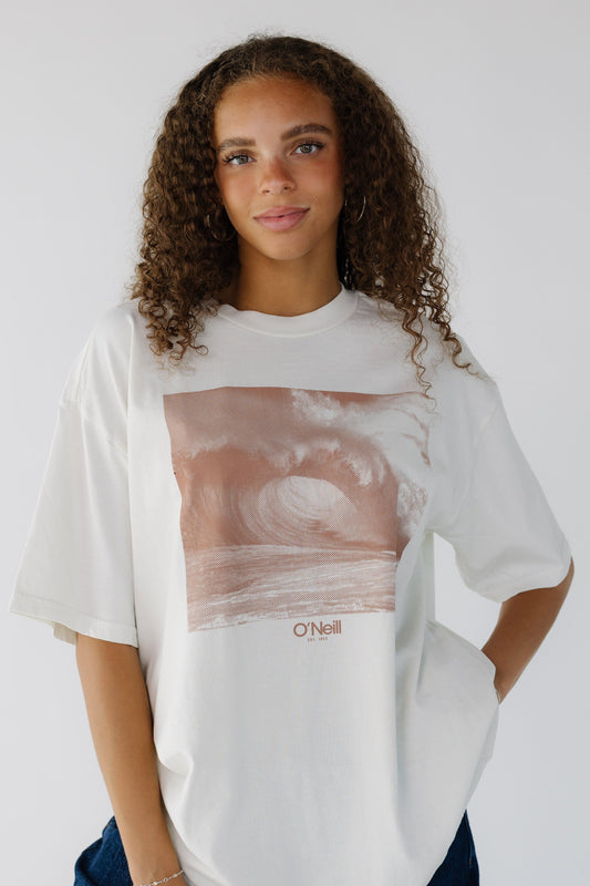 Teen girls wearing an oversize light cream tee with a large front graphic in brown with short sleeves.