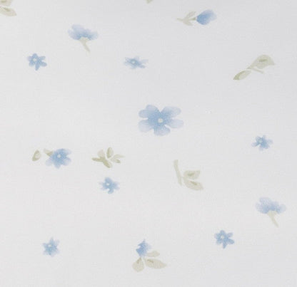 Fabric swatch of off white with a blue scattered floral print.