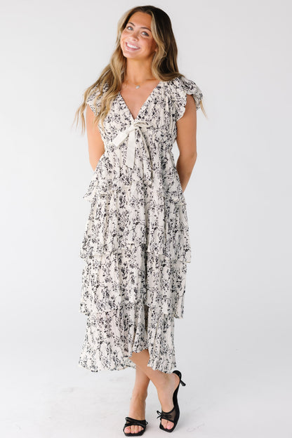 Woman wearing a multi tiered and ruffled midi dress in white print