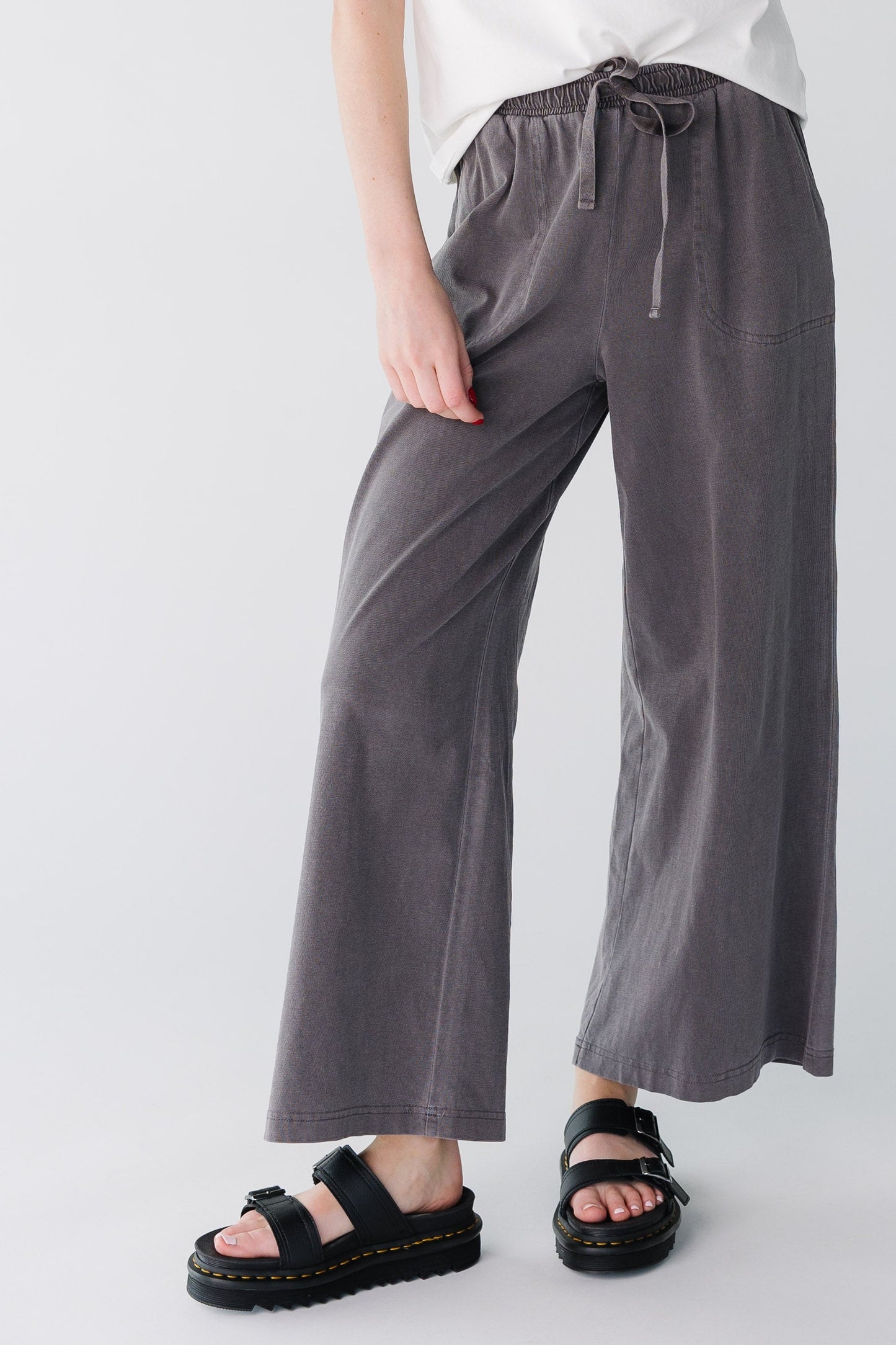 Woman wearing a pair of modest wide leg, loose fitting pants with elastic-drawstring waist.