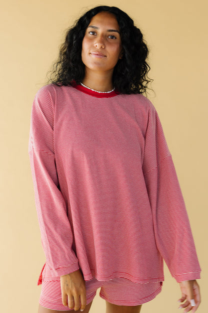Young woman wearing a modest red & white stripe , very loose fitting top with long sleeves and a crew neckline.