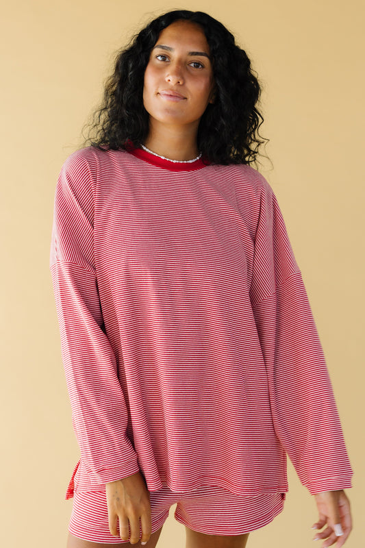 Young woman wearing a modest red & white stripe , very loose fitting top with long sleeves and a crew neckline.