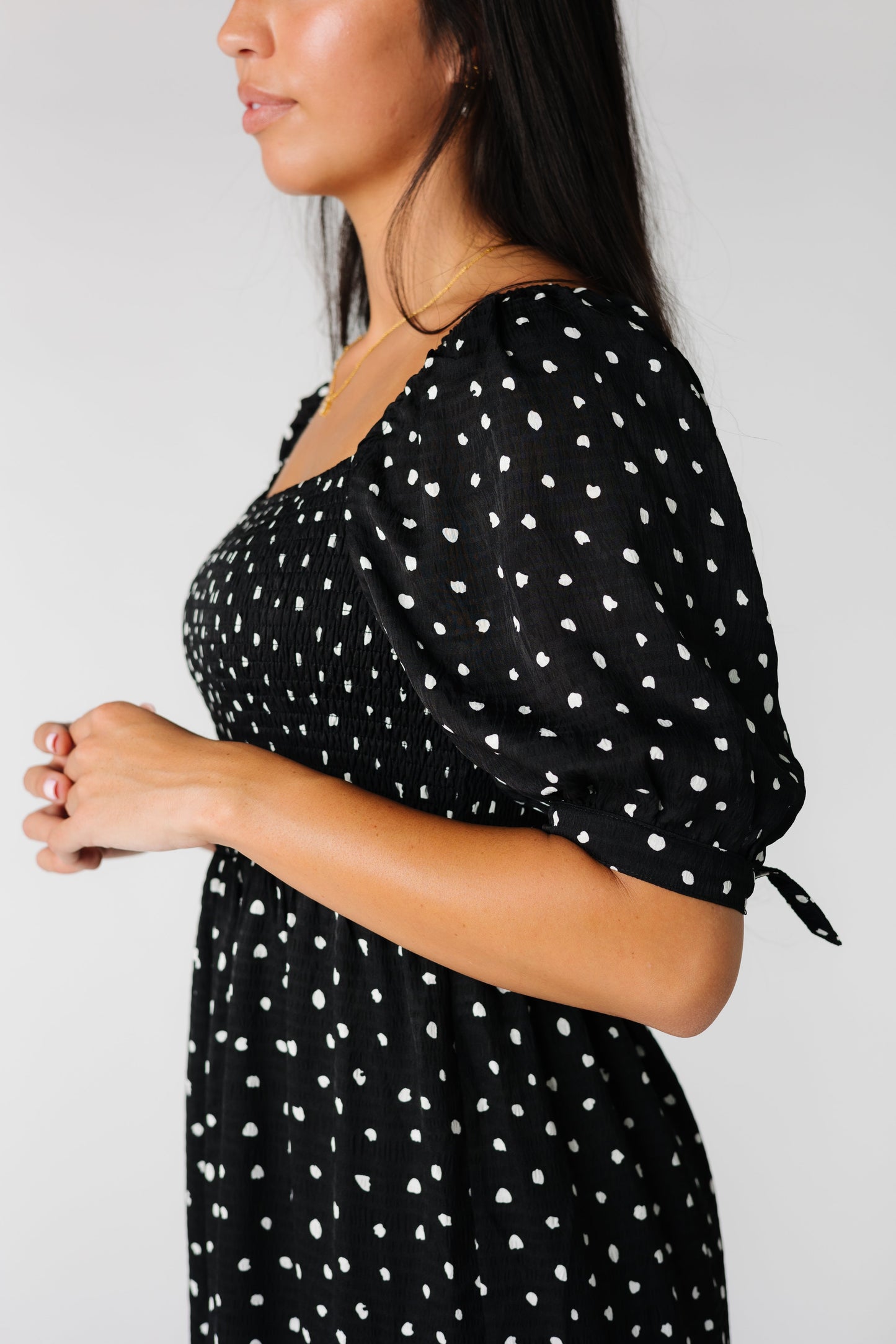 Close view of black polka dot dress with square neckline