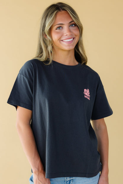 Young woman wearing a modest black short sleeve graphic tee with short sleeves and a small front graphic.