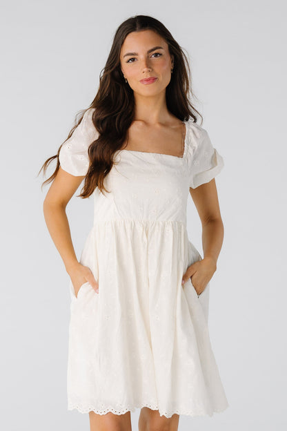 Light natural knee length eyelet dress with  short sleeves and eyelet lace scallop hem