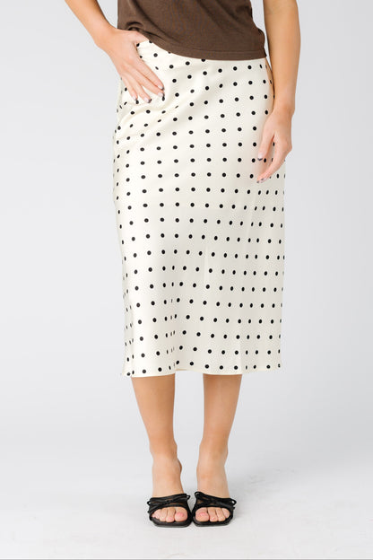 Woman wearing modest A-line midi skirt in cream with black polka dots