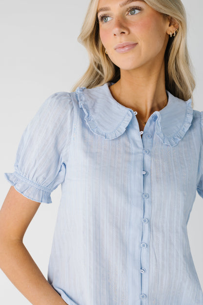 Close up of light blue textured button down top