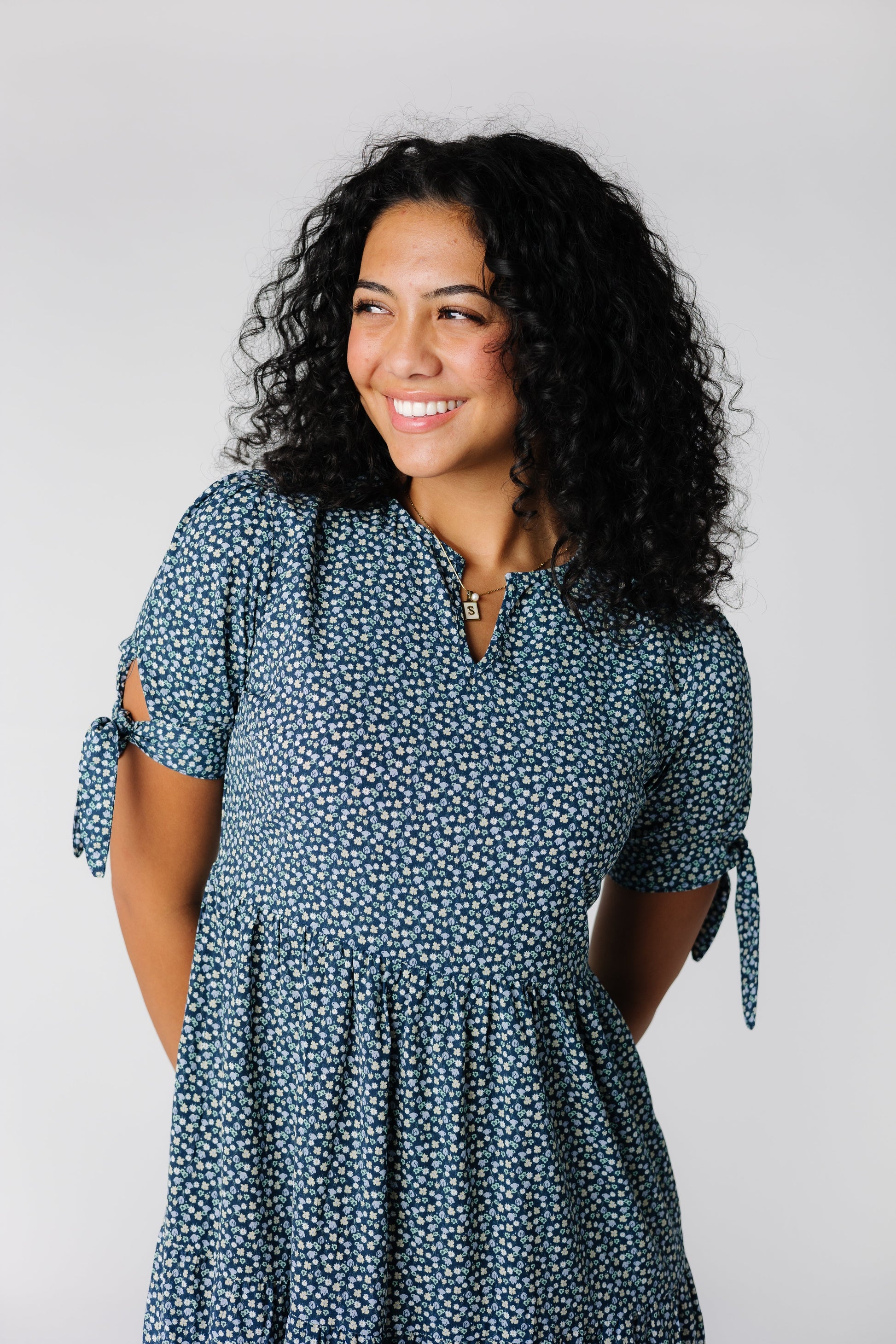 Close view of floral print dress with notched neckline and short sleeves with ties